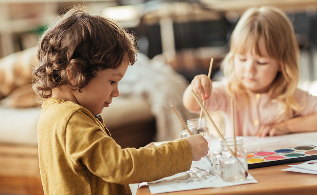 Les enfants réalisent des activités de peinture sur une table