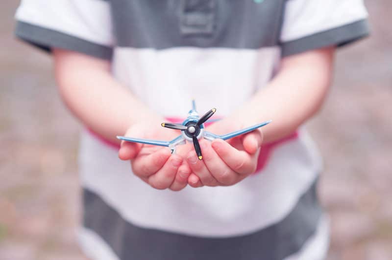 main d'un petit garçon jouant avec un avion miniature grande classe